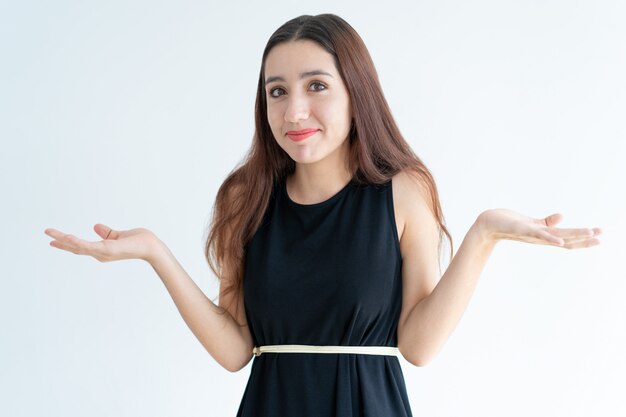 Retrato de mujer joven sonriente encogiéndose de hombros