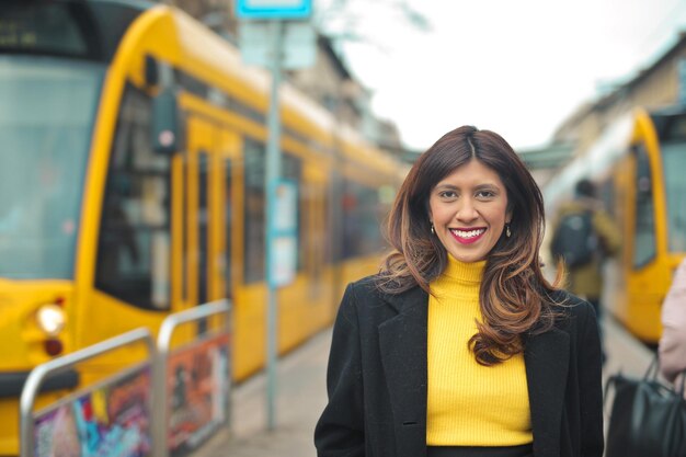 retrato de mujer joven sonriente. en el fondo dos tranvías