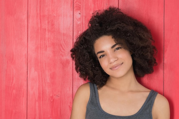 retrato, de, un, mujer joven, sonriente, posar, encima, rojo, fondo de madera