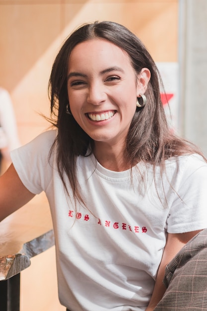 Foto gratuita retrato de una mujer joven sonriente que mira la cámara