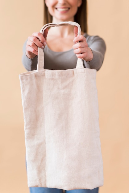 Retrato de mujer joven sonriente sosteniendo una bolsa reutilizable