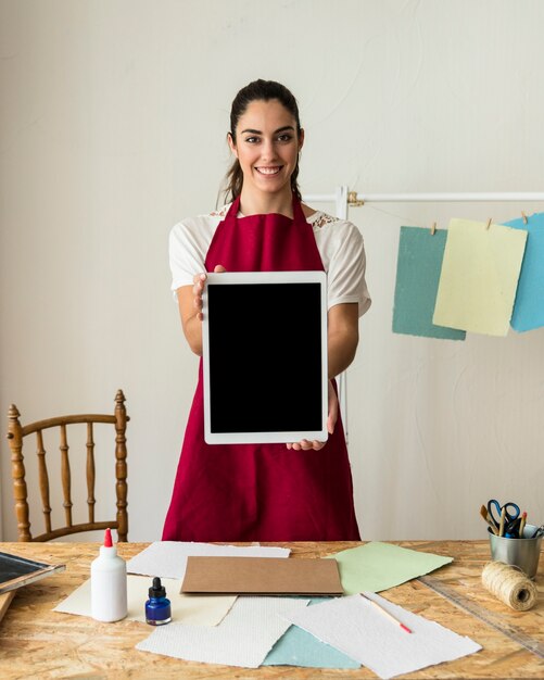 Retrato de una mujer joven sonriente con tableta digital