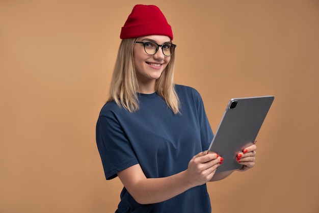 Foto gratuita retrato, de, un, mujer joven, sonriente, y, tenencia, un, tableta