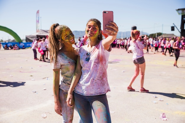 Retrato de una mujer joven sonriente tomando selfie en teléfono móvil