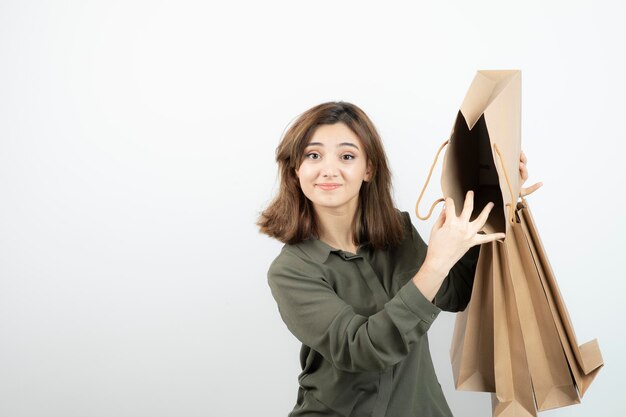 Retrato de mujer joven sosteniendo bolsas de papel artesanal y de pie. foto de alta calidad