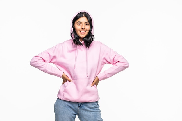 Retrato de una mujer joven con una sudadera con capucha posando aislado en la pared blanca