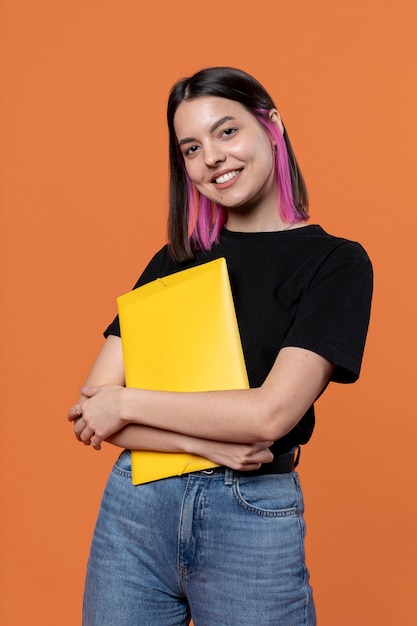 Foto gratuita retrato de una mujer joven sujetando su carpeta