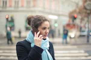 Foto gratuita retrato de mujer joven en el teléfono en la calle