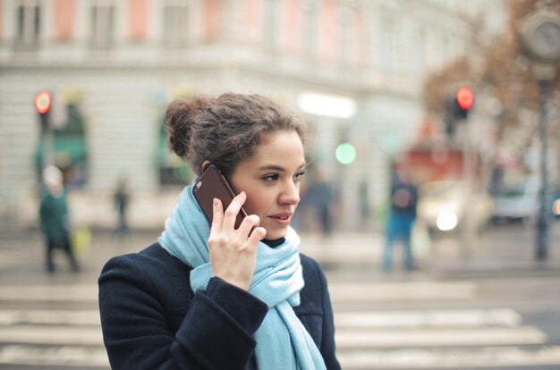 Retrato de mujer joven en el teléfono en la calle