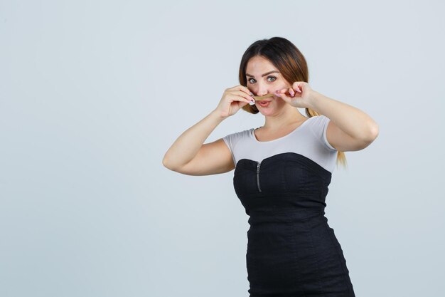 Retrato, de, mujer joven, tenencia, ella, pelo, como, bigote