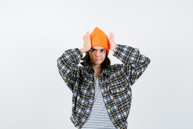 Retrato, de, mujer joven, tenencia, palmas, en, cabeza, en, sombrero naranja