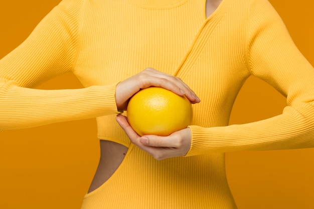 Foto gratuita retrato, de, mujer joven, tenencia, pomelo