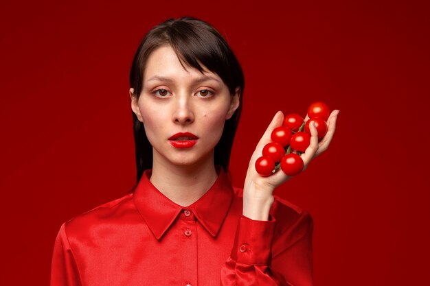 retrato, de, mujer joven, tenencia, tomates cherry