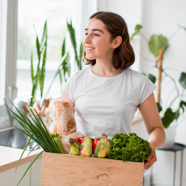 Retrato, de, mujer joven, tenencia, vegetales orgánicos