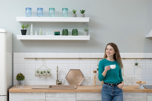 Retrato de mujer joven tomando un café en casa