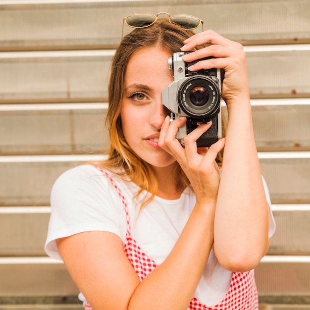 Foto gratuita retrato de mujer joven tomando foto con camara