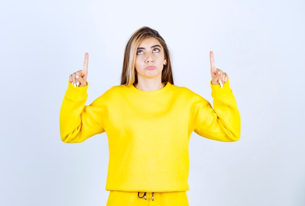 Retrato de mujer joven en traje amarillo posando para la cámara