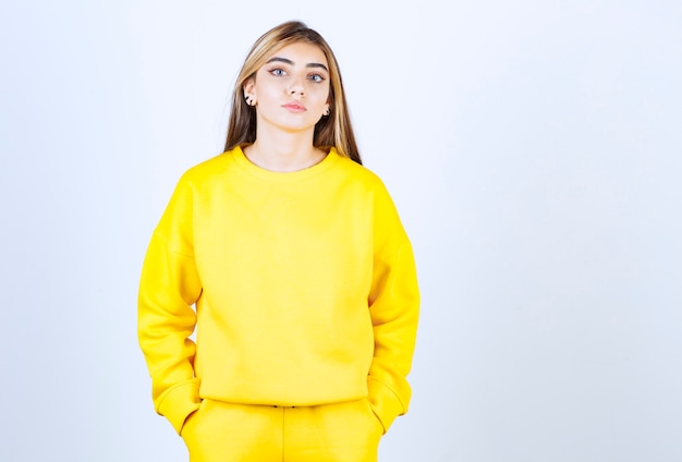Foto gratuita retrato de mujer joven en traje amarillo posando y de pie