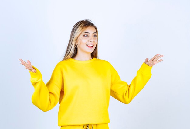 Retrato de mujer joven en traje amarillo posando y de pie