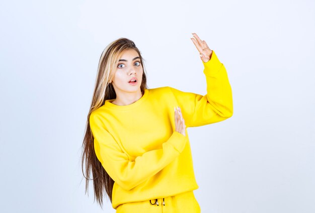 Retrato de mujer joven en traje amarillo posando y de pie