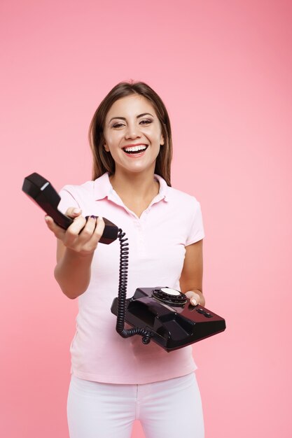 Retrato de mujer joven en traje casual fresco hace llamadas telefónicas