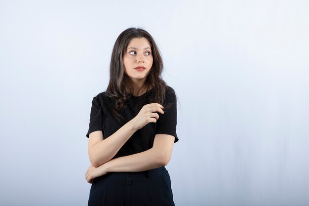 Retrato de mujer joven en traje negro mirando en algún lugar.