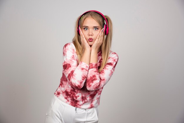 Foto gratuita retrato de mujer joven en traje rosa sosteniendo su rostro.