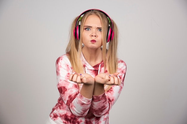 Foto gratuita retrato de mujer joven en traje rosa sosteniendo sus manos a la cámara.