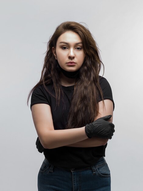 Retrato de mujer joven triste con las manos cruzadas y guantes negros