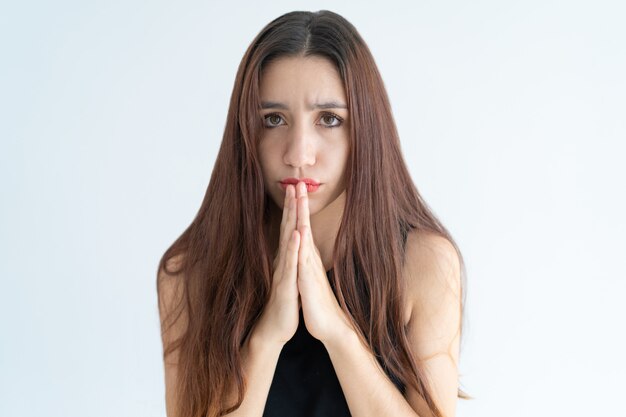 Retrato de mujer joven triste pidiendo o pidiendo algo