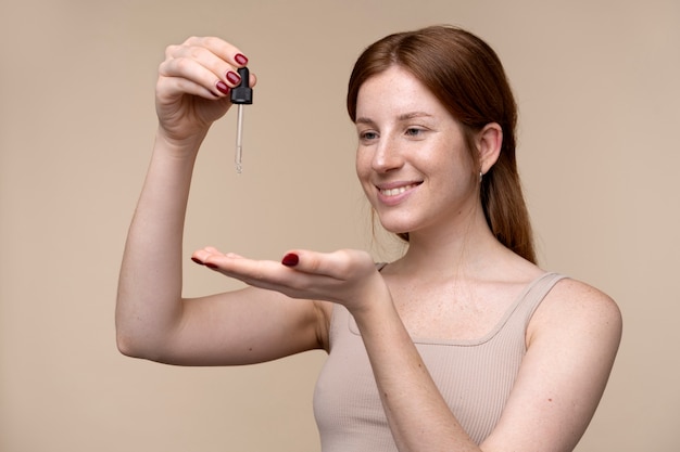 retrato, de, un, mujer joven, verter, suero, en, ella, mano