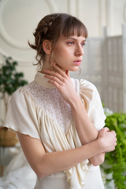 Retrato de mujer joven en vestido boho con estética de jardín romántico y vegetación.