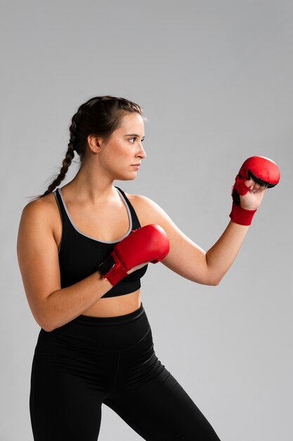 Retrato de mujer de lado golpeando con guantes de box
