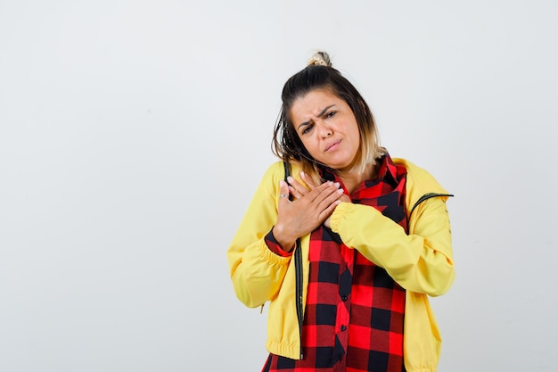 Retrato de mujer linda cogidos de la mano en el pecho en camisa, chaqueta y mirando triste vista frontal