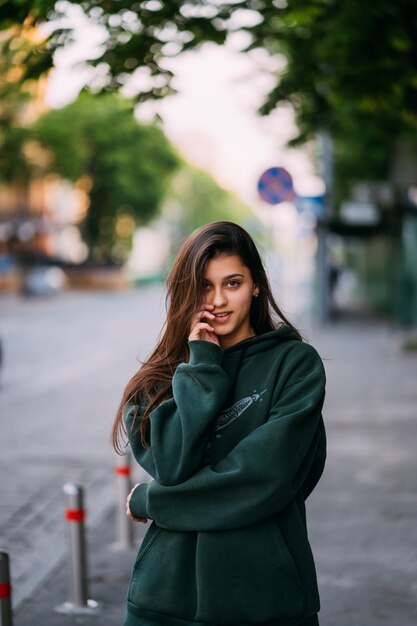 Retrato de mujer linda con el pelo largo, posando en la calle