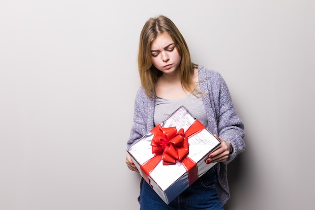 Retrato de una mujer linda sonriente abriendo caja de regalo