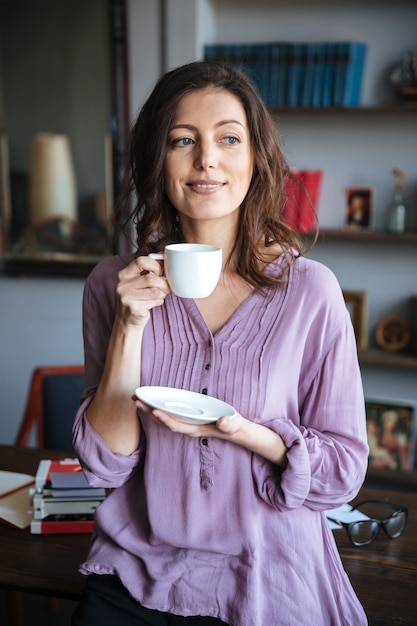 Retrato de mujer madura relajada sonriente sosteniendo la taza de café