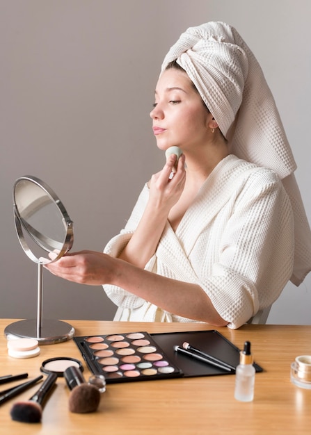 Foto gratuita retrato mujer maquillaje con esponja en espejo