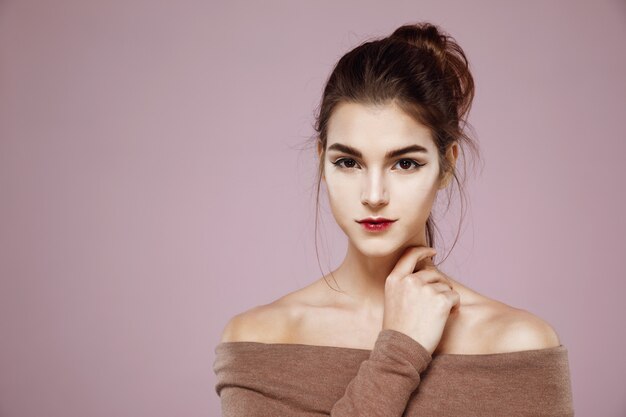 Retrato de mujer con maquillaje posando en rosa