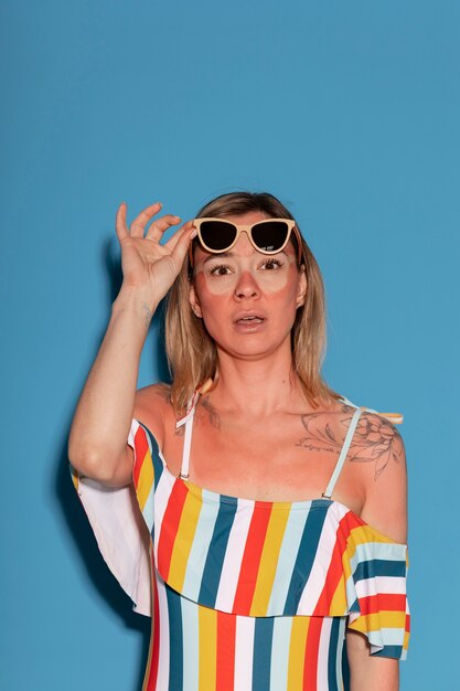 Retrato de mujer con marcas de quemaduras solares en la piel y gafas de sol