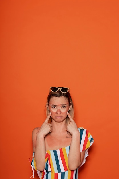 Retrato de mujer con marcas de quemaduras solares en la piel y gafas de sol