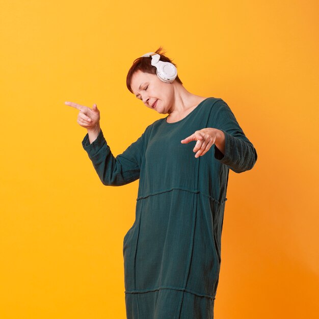 Foto gratuita retrato de mujer mayor bailando y escuchando música