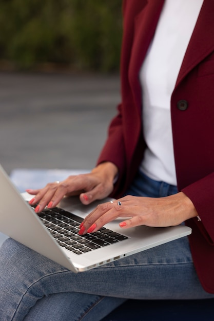 Foto gratuita retrato de mujer mayor en blazer profesional al aire libre y portátil