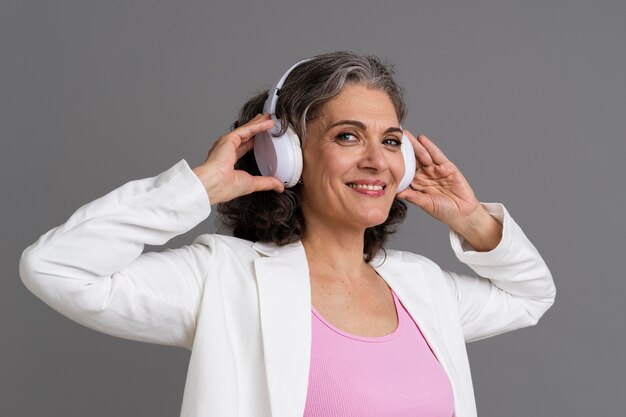 Retrato de mujer mayor elegante con un par de auriculares