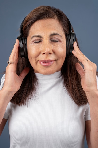 Foto gratuita retrato de mujer mayor escuchando música a través de auriculares