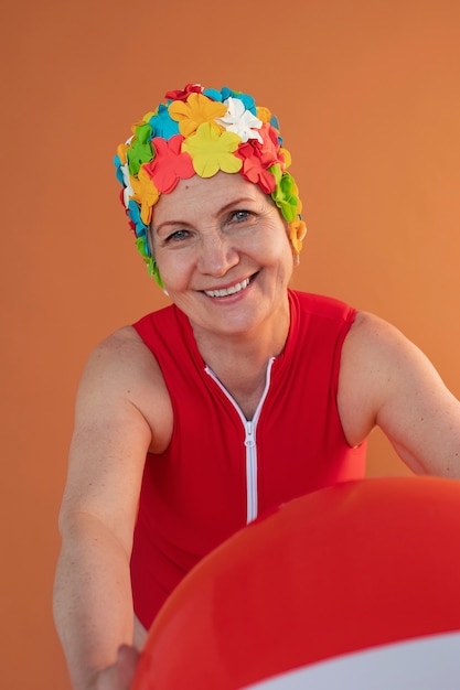 retrato, de, mujer mayor, con, floral, gorra de baño, y, pelota