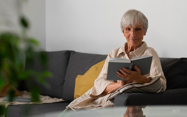 Foto gratuita retrato de una mujer mayor leyendo un libro en casa