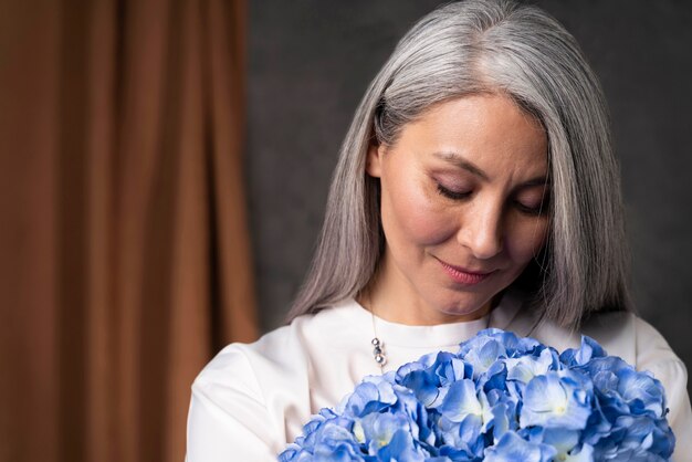Retrato de mujer mayor con ramo de flores