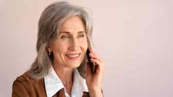 Foto gratuita retrato de mujer mayor sonriente tomando el teléfono