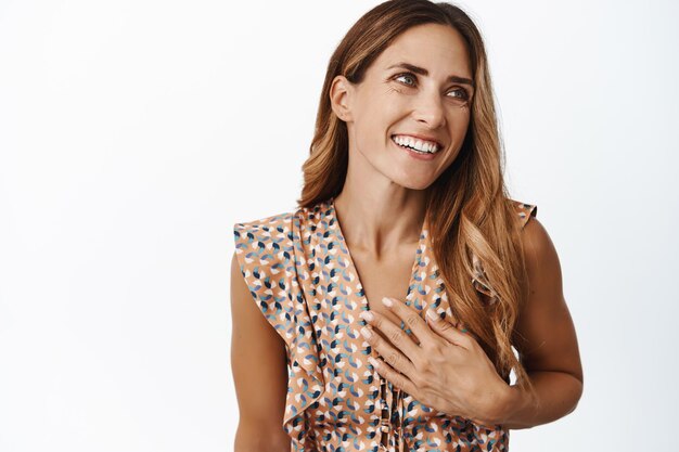 Retrato de mujer de mediana edad tierna y hermosa con sonrisa blanca piel perfecta y saludable sin arrugas tomados de la mano sobre fondo blanco del pecho